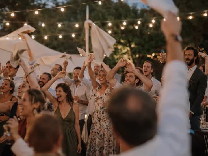 Accueil des mariés par les convives en musique qui font tourner les serviettes